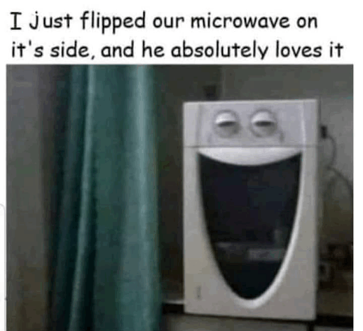 A microwave turned on its side appears to have a cartoon face with a smile